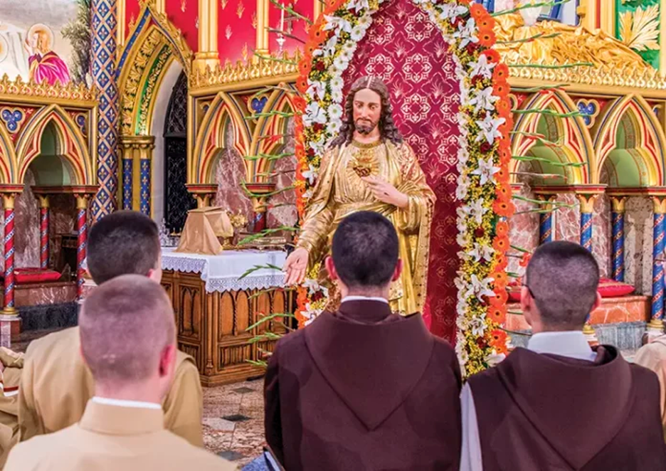 Heralds at the feet of a statue of the Sacred Heart of Jesus, in the Basilica of Our Lady of the Rosary, Caieiras, Brazil. (Photo lifted from the Herald's magazine.)